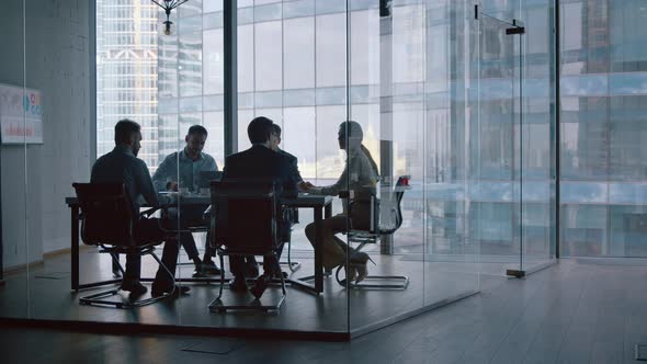 Business partners shaking hands after a completed deal in boardroom