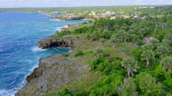 Drone View Flying Across Rugged Tropical Coastline Towards Boca De Yuma Town and Harbour, Dominican