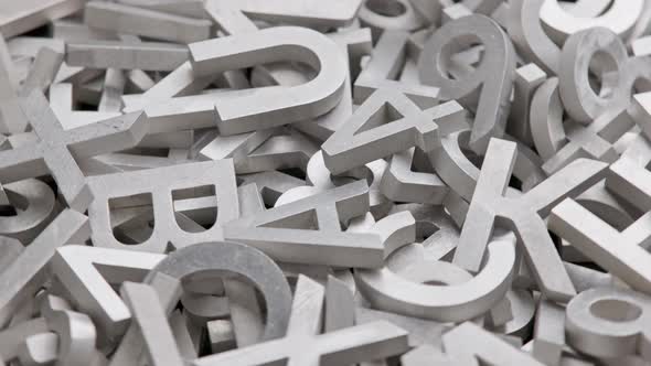 Full Frame Closeup Looped Rotating Background of Silver Metal Letters with Selective Focus