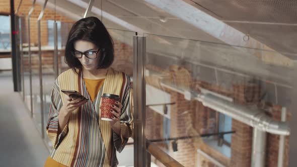 Female Office Worker Texting on Smartphone during Coffee Break