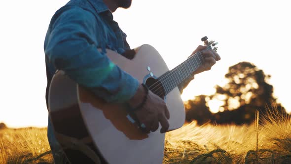 Musician playing guitar slow motion cinematic field