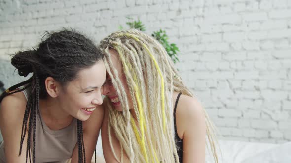 Young Caucasian Woman in the Morning Laugh in Bed with Friend