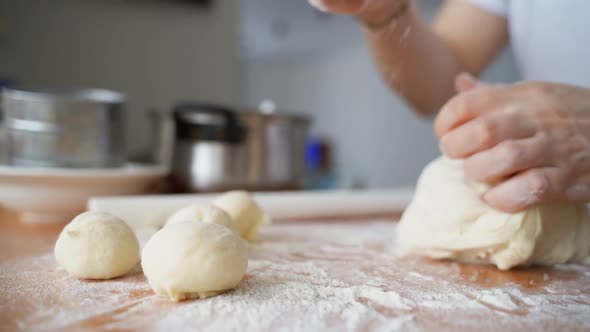 The Woman Divides the Dough Into Equal Pieces