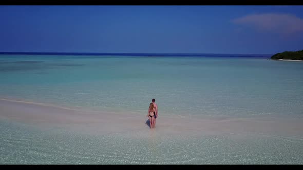 Two people suntan on luxury lagoon beach break by clear water with white sand background of the Mald