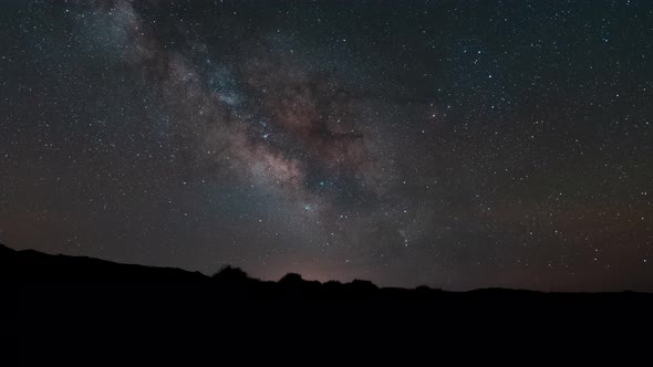 The center of the Milky Way Galaxying across the sky over the desert horizon - time lapse