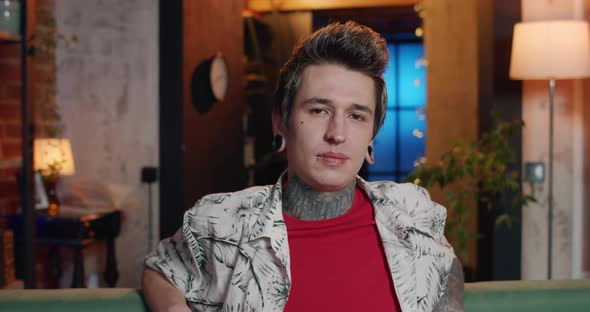 Close Up View of Young Man with Tattoos and Piercing Looking To Camera with Serious Face, Portrait