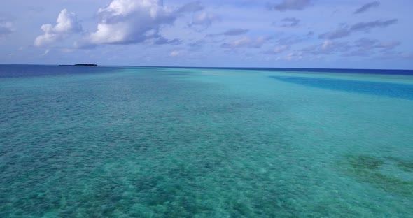 Beautiful birds eye island view of a paradise sunny white sand beach and blue sea background in colo