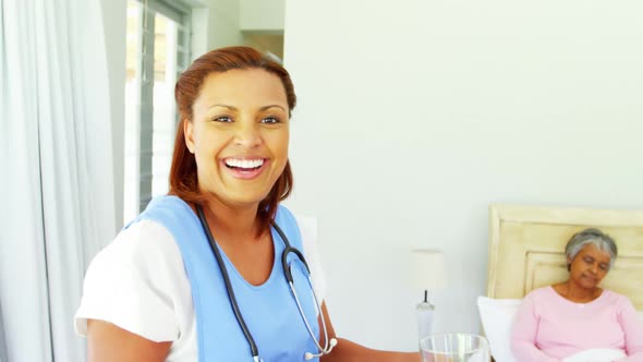 Smiling female doctor serving breakfast to senior woman on bed 4k