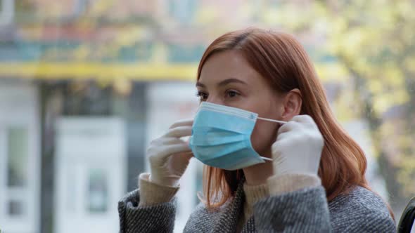 Female Passenger Wearing Gloves Puts Medical Mask on Her Face While Traveling in Public Transport