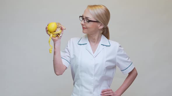 Nutritionist Doctor Healthy Lifestyle Concept - Holding Ginger Root, Lemon Fruit and Measuring Tape