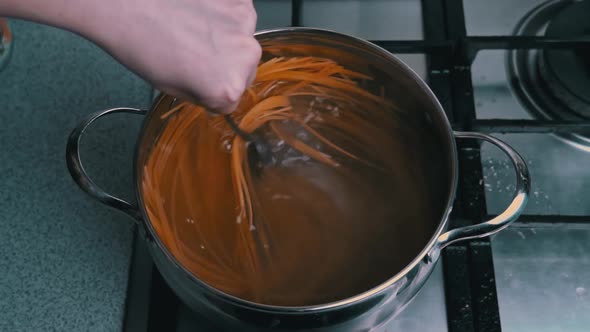 Female Hands Stir Spaghetti in a Saucepan with Boiling Water Slow Mo