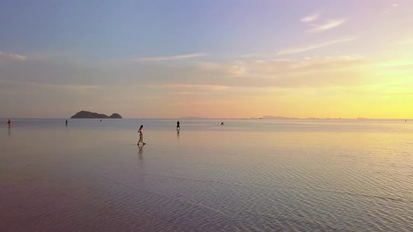 Young Woman Walking Alone on the Water In the Sea at Beautiful Sunset Thailand