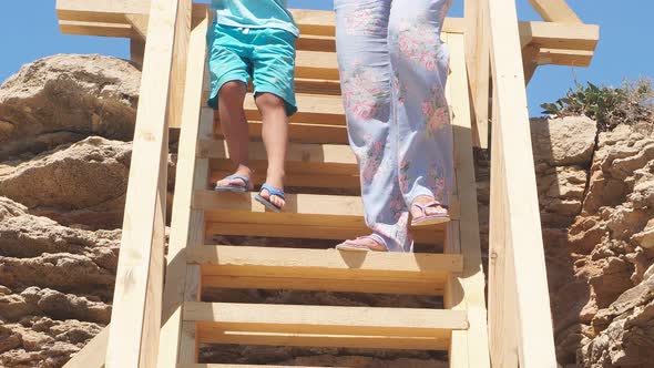 Closeup of Feet Descending a Steep Wooden Staircase to the Sea View From the Bottom