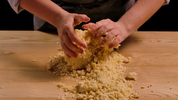 Woman Kneads Dough on the Kitchen Table