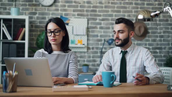 Cinemagraph Loop of Man Moving Pen in Hand Working in Office with Woman