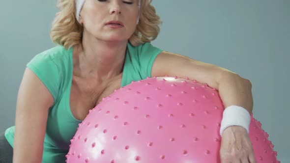 Sleepy Tired Middle-Aged Woman Lying on Fitness Ball After Active Workout