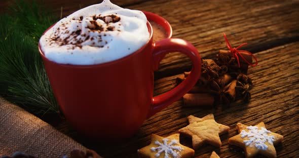 Coffee mug with christmas cookies on a plank