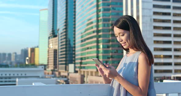 Woman using mobile phone in city 