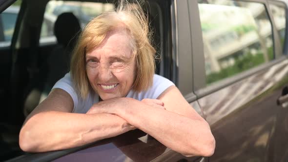 Happy Senior Woman Driving Sitting in New Brown Car Smiling Looking at Camera Enjoying Journey