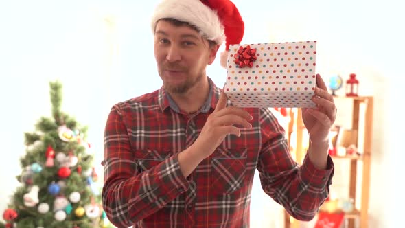 A Man in a Plaid Shirt Gives a Christmas Present