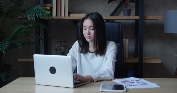 Closeup of Asian Businesswoman Reading Bad News on Laptop