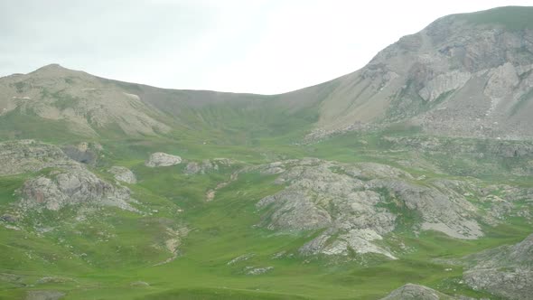 Panning around the large landscape of green hills in Barcelonnette, France.