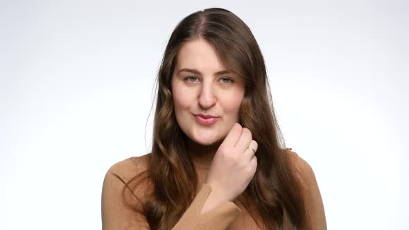 Studio Portrait of Young Woman Locking Her Mouth with Invisible Lock and Throwing Away Key