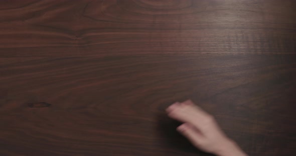 Top View Slow Motion Man Dust Off Black Walnut Table