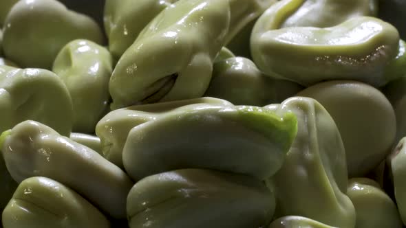 Close up of Fava beans spinning. The beans have been boiled so the skin is wrinkled and loose and re