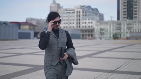 Serious Successful Elegant Businessman in Sunglasses Walking in Slow Motion on Urban City Street