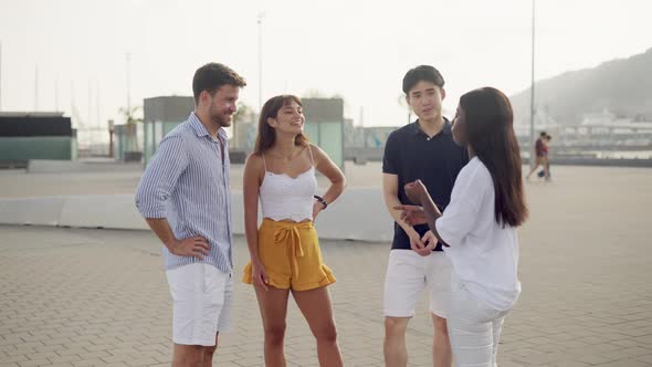 Smiling Diverse People Enjoying Pleasant Conversation During Meeting on Embankment on Summer Day