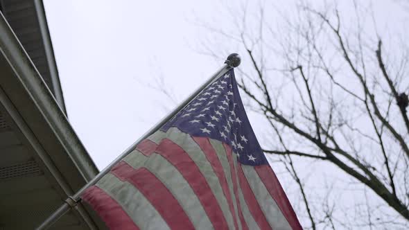 Close Up Shot of American Flag on a Front Porch on a Breezy Day