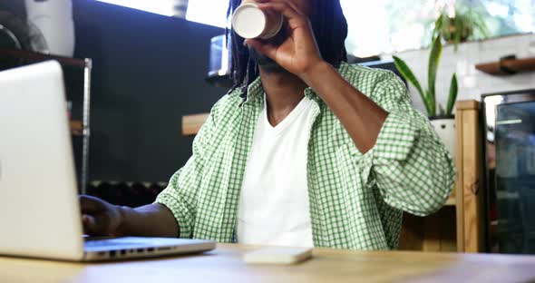 Man using laptop while having coffee