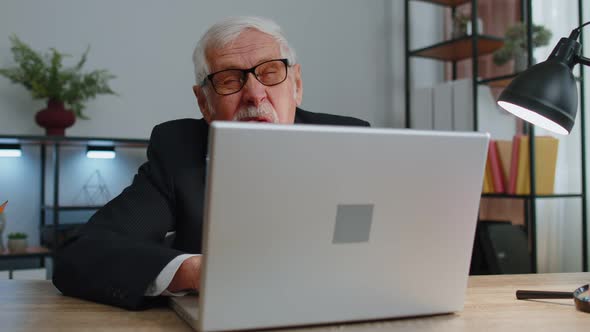 Senior Mature Older Business Man Hiding Behind Laptop Computer Making Funny Face Fooling Around