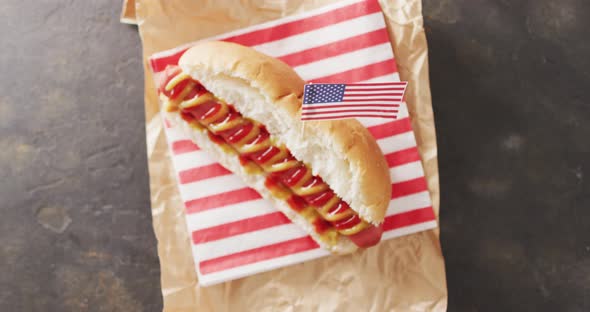 Video of hot dog with mustard and ketchup with flag of usa on a black surface