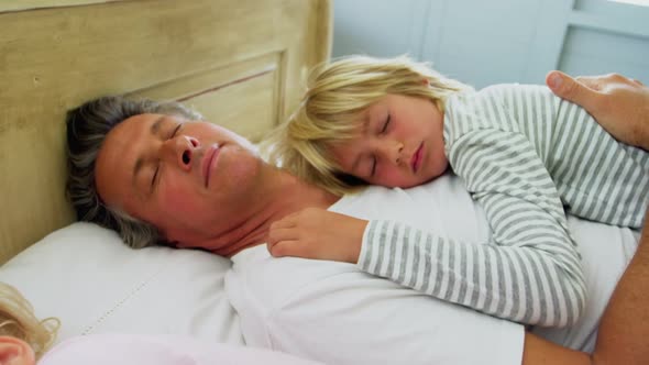 Family sleeping on bed in the bed room 4k