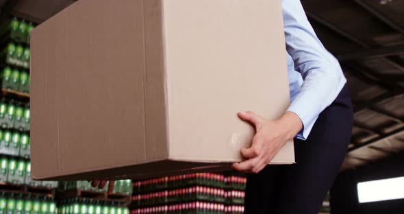 Female worker arranging box in warehouse