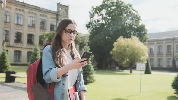 Young Woman Tourist Looking for Geolocation on the Street Using a Smartphone