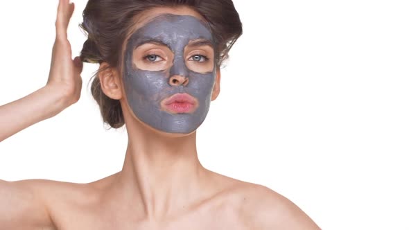 Topless Female Model with Facial Mask Posing Over White Background in Slowmotion