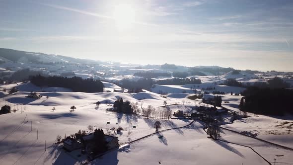 Wonderful flight over snowy fields and hills in Switzerland while winter.