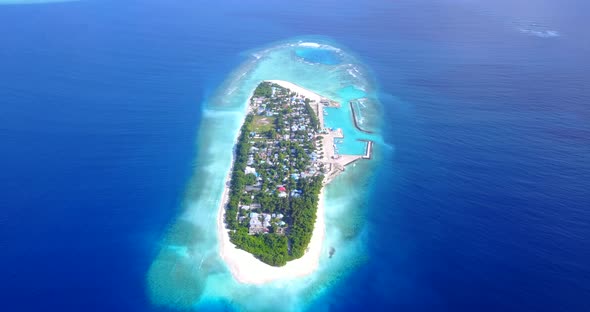 Luxury aerial tourism shot of a white sandy paradise beach and blue water background in hi res 4K