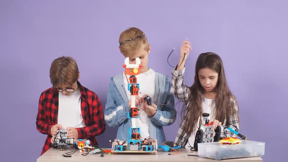 Caucasian Friends Kids Studying Engineering, Robotics, Try To Assemble Robots