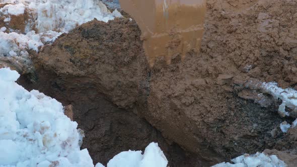 Loader Digging Wet Ground in Winter