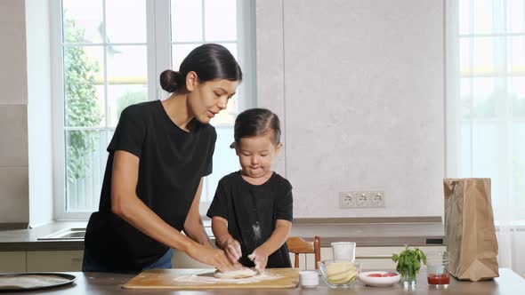 Mother and Little Daughter Stir and Stretch Elastic Dough