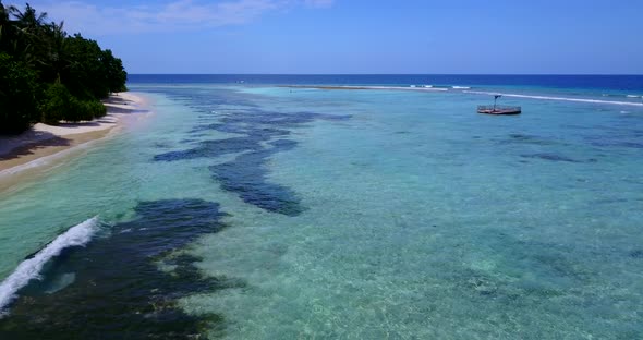 Tropical flying copy space shot of a white sand paradise beach and blue water background in high