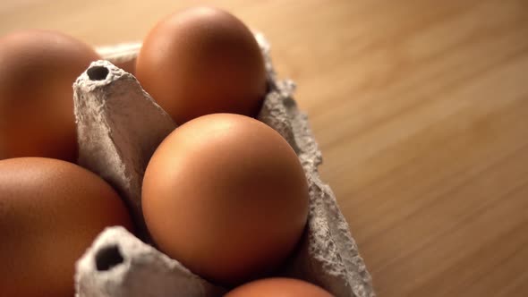 close up of brown eggs in egg carton on rustic background