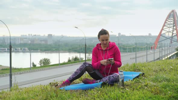 Fit Woman Listening Music While Workout at Park