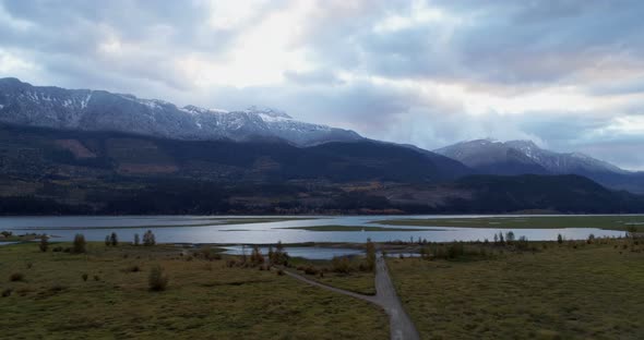 Scenic view of mountain ranges, lake and grassland