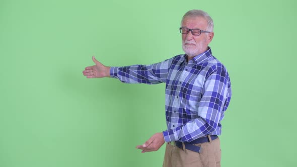 Stressed Senior Bearded Hipster Man Showing To Back and Giving Thumbs Down