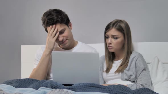 Online Loss Young Couple in Bed Reacting to Failure